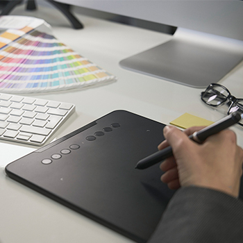 Woman freelance graphic designer at work in her home office chooses colors tonex.bg
